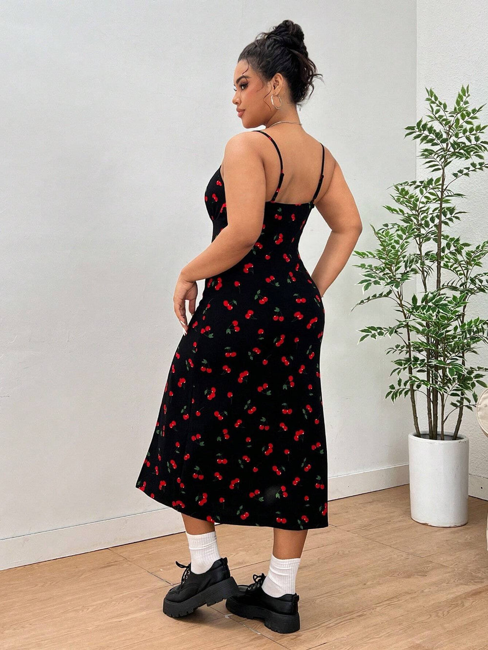 Vestido midi de tirantes finos con estampado de cerezas y abertura alta, modelo de frente.