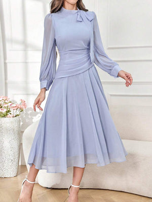 Detalle del fruncido en la cintura de un vestido elegante de gasa celeste.
