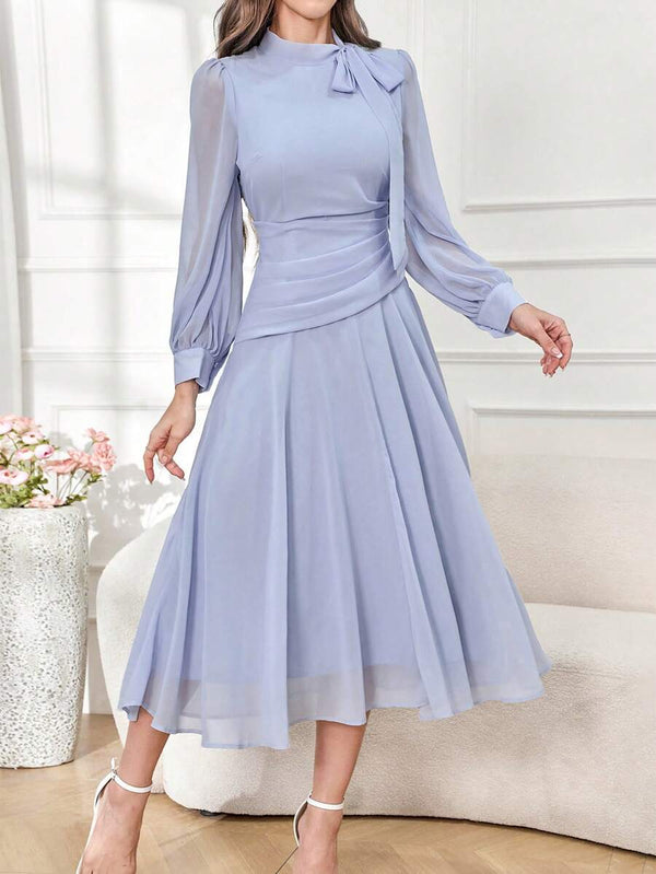 Detalle del fruncido en la cintura de un vestido elegante de gasa celeste.