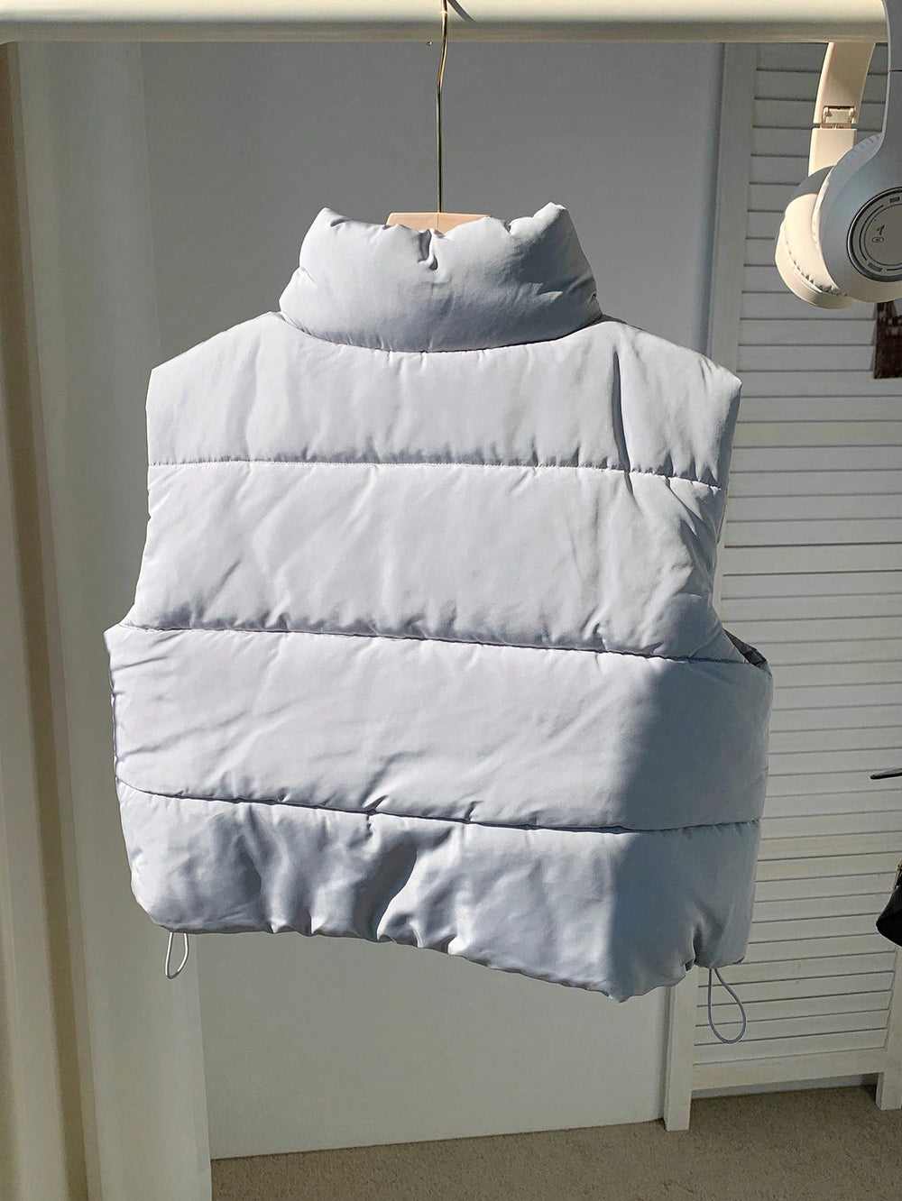 Chaleco gris claro acolchado para mujer en vista frontal.