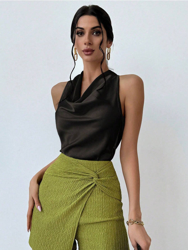 Top elegante negro de satén combinado con falda verde.