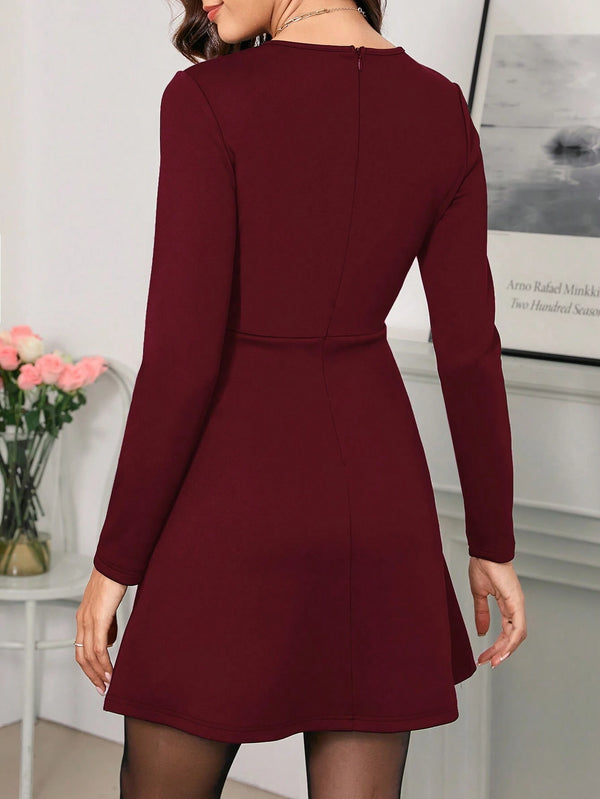 Vestido elegante burdeos de manga larga – detalle cintura y bolsillos.