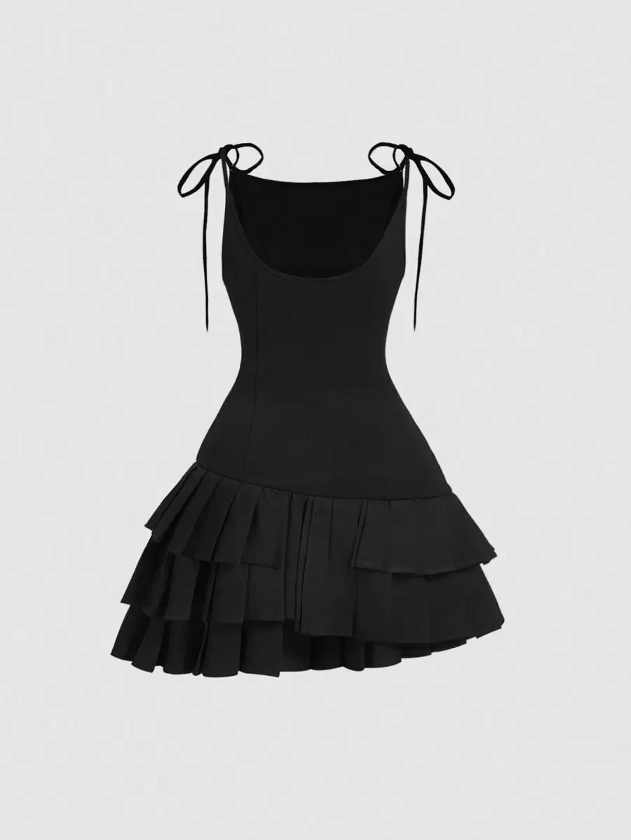 Vista frontal del vestido mini negro con tirantes y capas