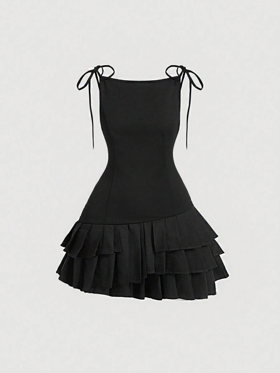 Vista frontal del vestido mini negro con tirantes y capas