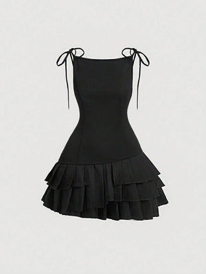 Vista frontal del vestido mini negro con tirantes y capas