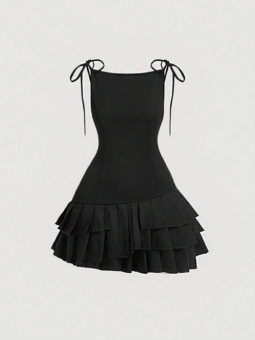 Vista frontal del vestido mini negro con tirantes y capas