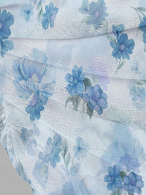 Silueta de un vestido ajustado con bajo de volantes, estampado floral, en un entorno de picnic veraniego.