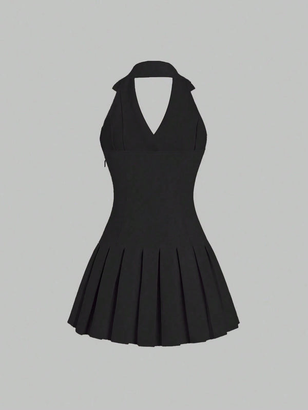 Vista trasera de vestido corto negro con solapa y plisado mostrando espalda al aire.