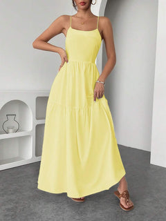 Detalle de la espalda al aire y tirantes cruzados de un elegante vestido largo amarillo.