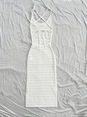 Detalle del escote y la espalda cruzada de un vestido blanco tejido.