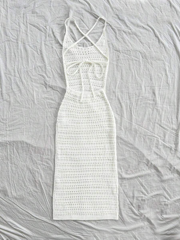 Detalle del escote y la espalda cruzada de un vestido blanco tejido.
