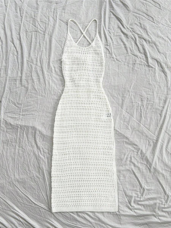 Conjunto de playa con vestido tejido blanco, sombrero de paja y sandalias de plataforma.