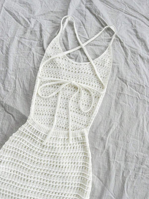 Primer plano de la textura calada de un vestido largo de tejido tipo crochet color blanco.