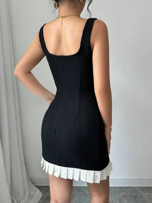 Espalda del vestido mini negro con detalle plisado blanco.