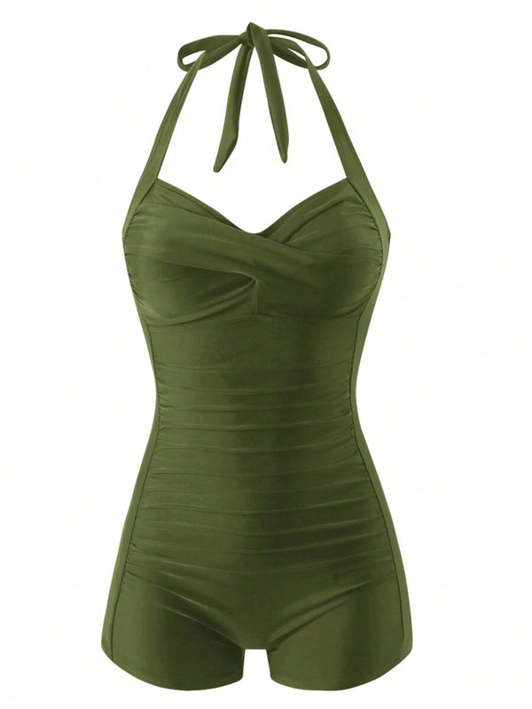 Vista lateral de una mujer usando un traje de baño entero verde olivo con detalles fruncidos en el torso.