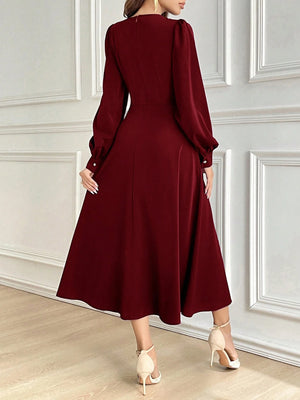 Vestido burdeos elegante largo con falda campana visto desde atrás.