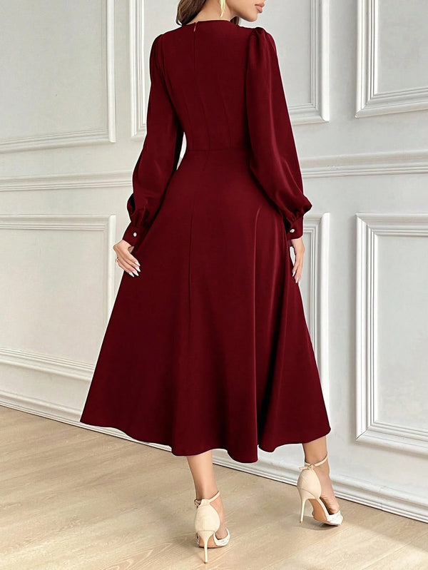 Vestido burdeos elegante largo con falda campana visto desde atrás.