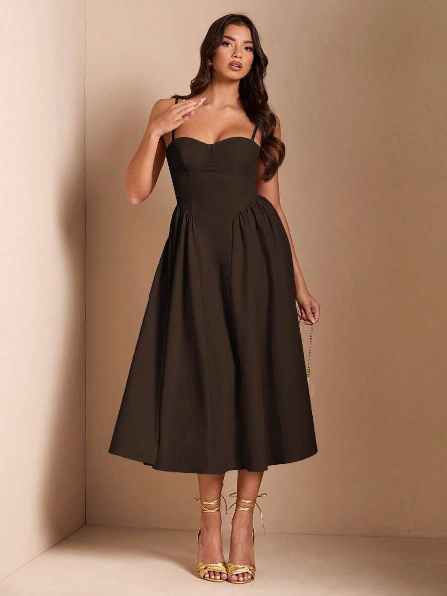 Mujer vistiendo un elegante vestido midi color café con escote corazón y tirantes finos.