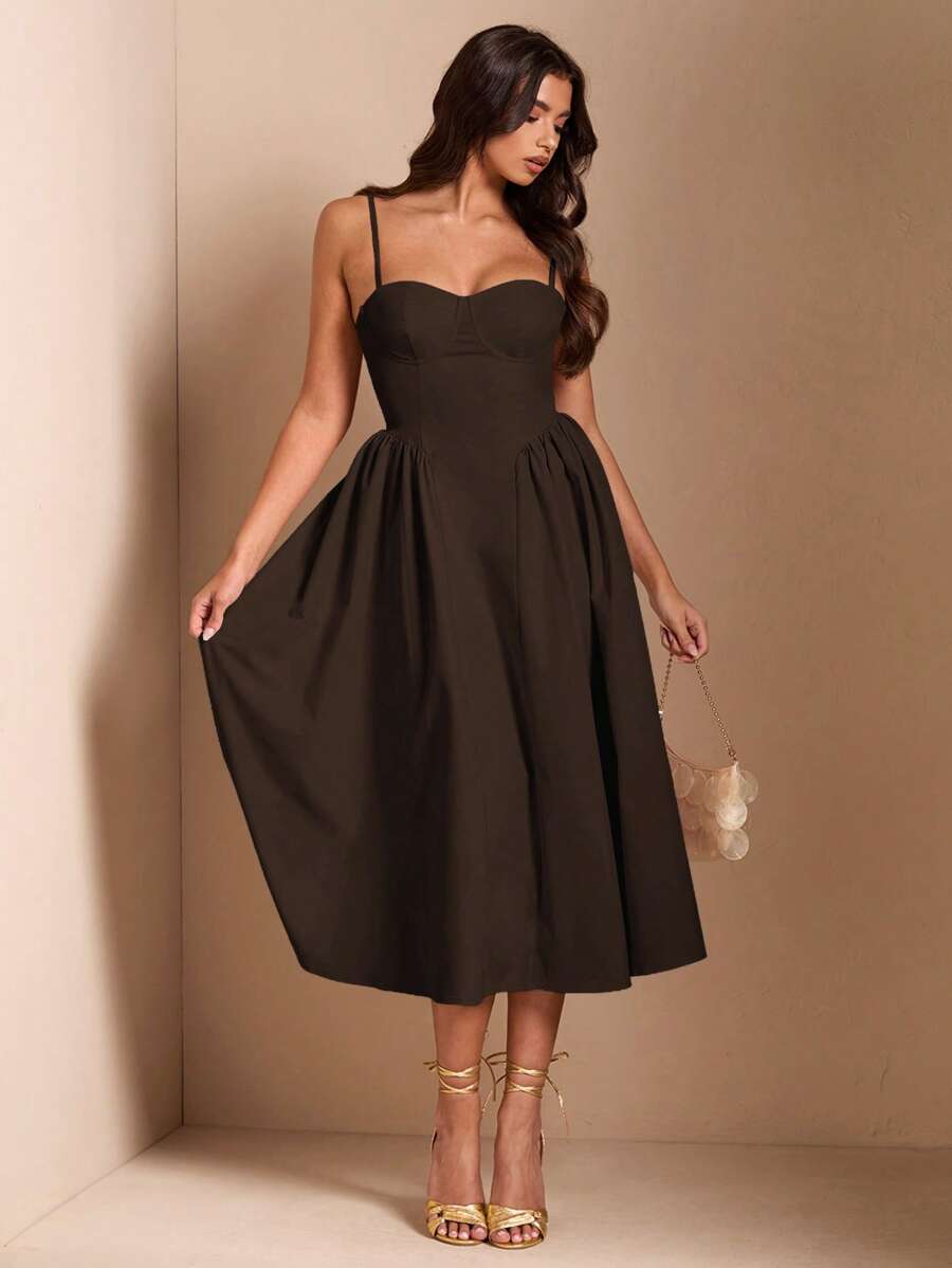 Mujer vistiendo un elegante vestido midi color café con escote corazón y tirantes finos.