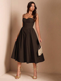 Mujer vistiendo un elegante vestido midi color café con escote corazón y tirantes finos.