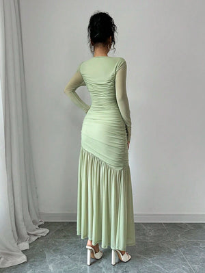 Vista de cerca del torso de un vestido verde menta con mangas de malla y detalle fruncido.