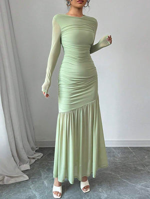 Detalle de la falda de un vestido largo verde menta con corte sirena asimétrico.