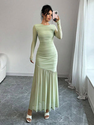 Look completo de un vestido largo verde menta con falda fluida y cuerpo ajustado.