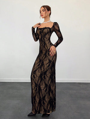 Vista lateral de una mujer con vestido de encaje negro de manga larga apoyada en un sillón.