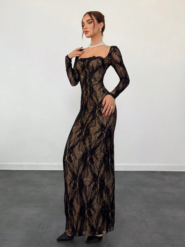 Vista lateral de una mujer con vestido de encaje negro de manga larga apoyada en un sillón.