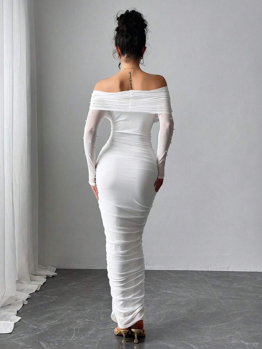 Vestido largo blanco elegante con hombros descubiertos y perlas visto desde el frente