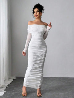 Vestido largo blanco elegante con hombros descubiertos y perlas visto desde el frente