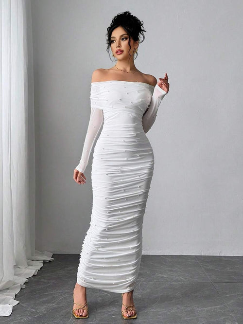 Vestido largo blanco elegante con hombros descubiertos y perlas visto desde el frente