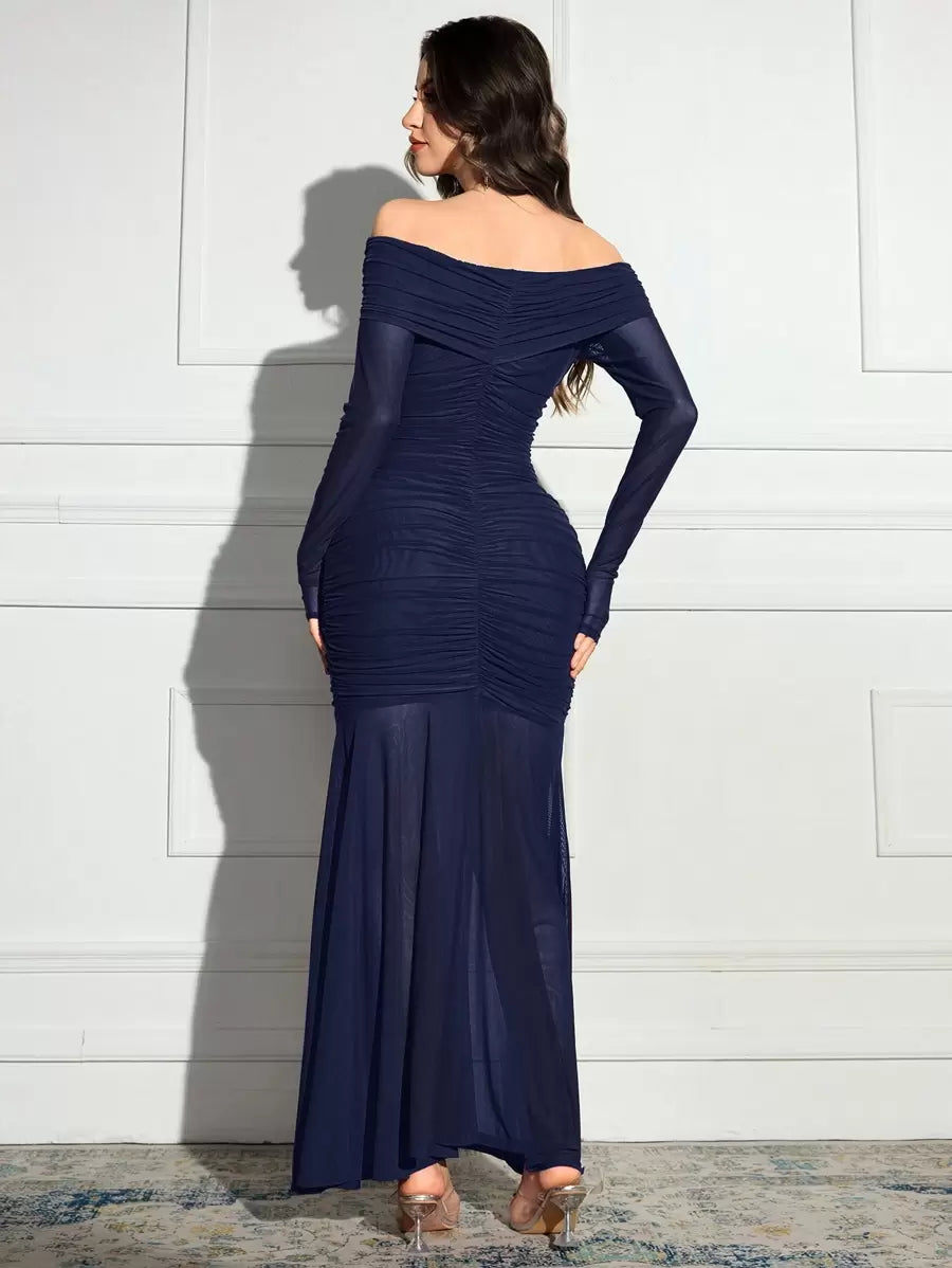 Vista completa de mujer vistiendo un vestido largo azul marino de fiesta con hombros descubiertos y falda de sirena.