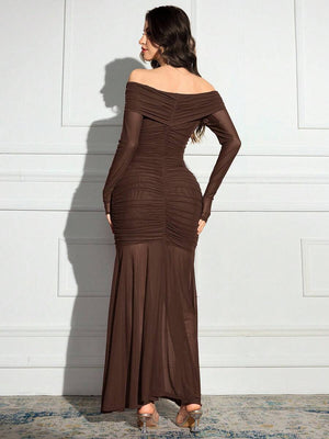Detalle de la falda estilo sirena de un vestido largo marrón de tejido semitransparente.