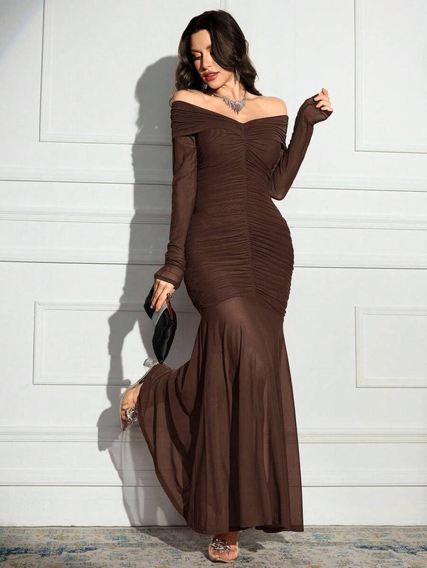 Perfil de una mujer luciendo un vestido de noche ajustado color marrón con diseño fruncido.