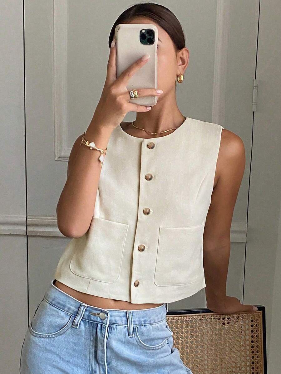 Mujer vistiendo un chaleco corto color crema con botones frontales y jeans de talle alto.