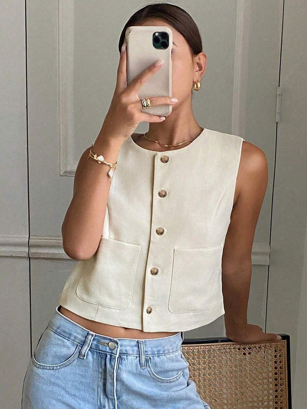 Mujer vistiendo un chaleco corto color crema con botones frontales y jeans de talle alto.