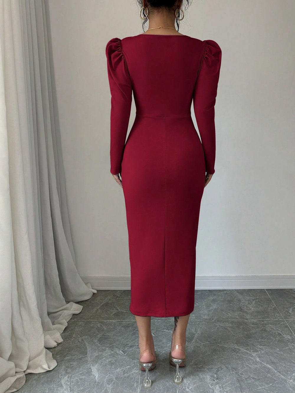 Modelo luciendo el vestido burdeos midi elegante con escote corazón y abertura frontal.
