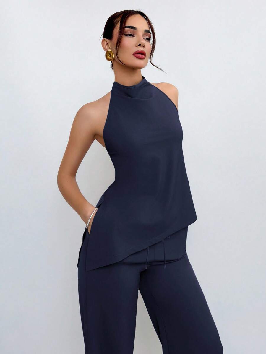 Mujer vistiendo un conjunto de dos piezas azul marino con top halter y pantalón de pierna ancha.