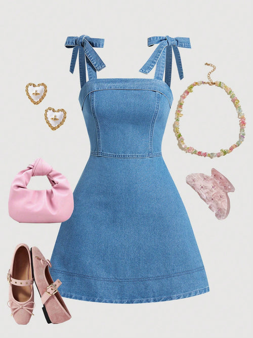 Vestido Mini De Mezclilla Azul Lavado Medio vista frontal con lazos en tirantes.
