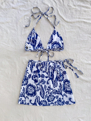 Conjunto De Playa Azul Y Blanco Con Top Halter Y Falda Mini sobre fondo claro.