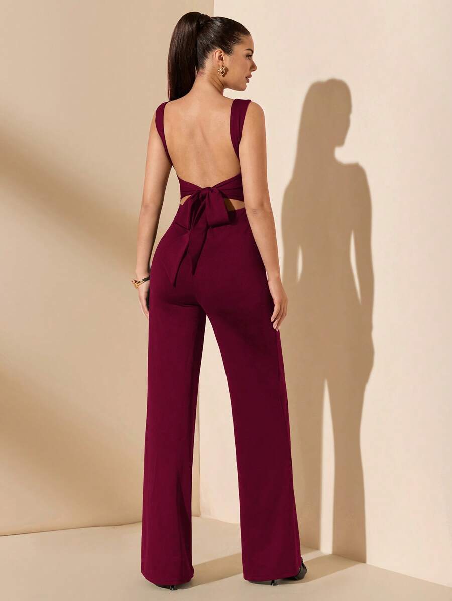 Primer plano de la espalda descubierta y el lazo de un jumpsuit color vino.