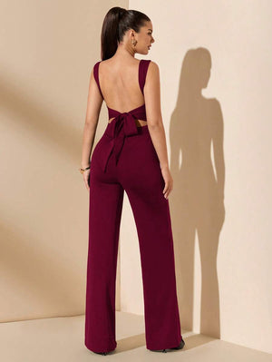 Vista trasera de mujer luciendo un jumpsuit elegante color vino con espalda descubierta y lazo.