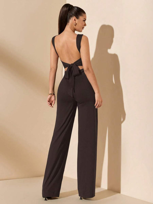 Modelo de espaldas luciendo un enterizo negro sofisticado con piernas rectas.