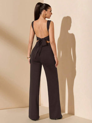 Jumpsuit elegante color negro con espalda descubierta y lazo, vista trasera de cuerpo completo.