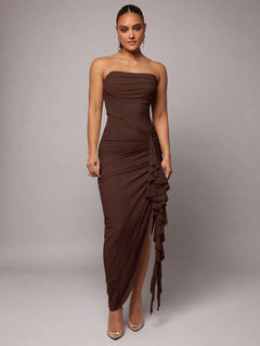 Vista frontal de un vestido elegante strapless color café con detalle drapeado lateral y volante en cascada.