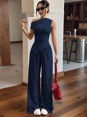 Detalle de los pantalones de pierna ancha y fluidos del jumpsuit azul marino.