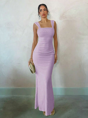 Mujer posando con un vestido largo color lavanda, detalle fruncido en el busto y espalda descubierta.
