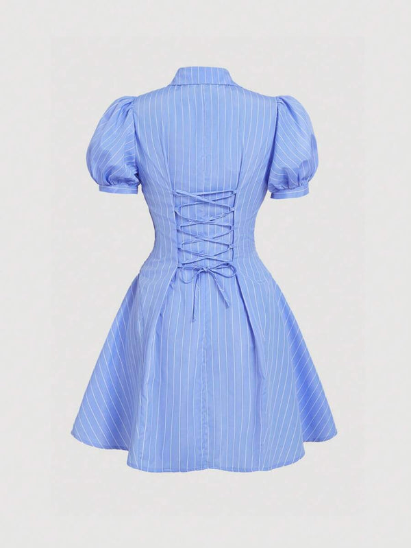 Detalle del cuello camisero y las mangas farol de un vestido azul a rayas.