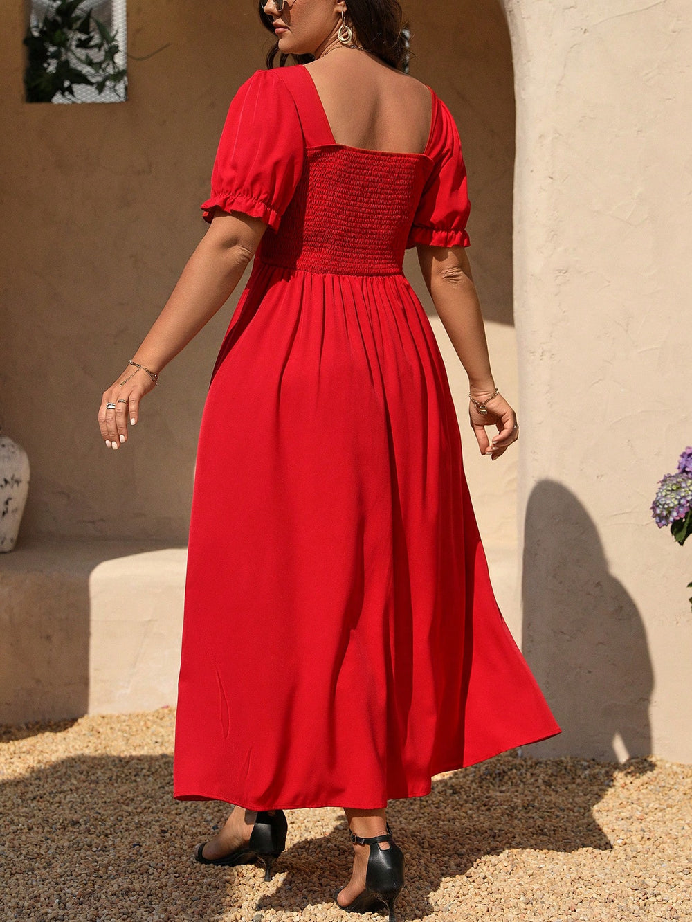 [Vista frontal de vestido rojo largo con abertura caminando bajo el sol.]